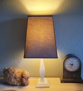 a teddy bear sitting on a table next to a clock at Domizil an der Huysburg in Dingelstedt +13 photos