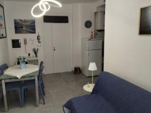 a living room with a blue couch and a table at Appartamento Mare Blu in Martinsicuro +13 photos