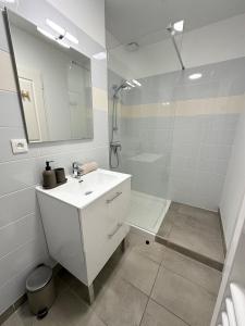 a white bathroom with a sink and a shower at 1- Hypercentre,FREE Parking, Clim, wifi, Netflix in Libourne +4 photos