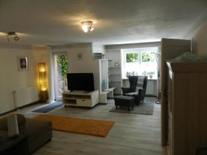 a living room with a tv and a couch and a chair at Helle Komfortwohnung in Möhnesee
