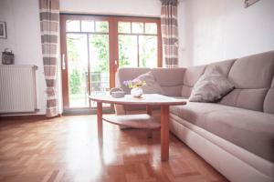 una sala de estar con un sofá y una mesa en Waldgasthof Röckers-Ferienwohnung Hahnenkrai, en Meppen
