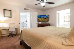 una camera con letto, scrivania e ventilatore a soffitto di Ranch Glam Townhome with Indoor Fireplace a El Paso