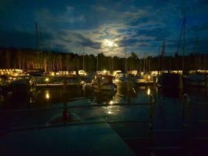 een groep boten aangemeerd in een jachthaven 's nachts bij Hausboot Marama - LP10 in Peenemünde