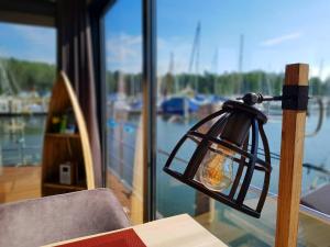 een lamp op een tafel met uitzicht op een boot bij Hausboot Marama - LP10 in Peenemünde