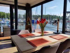 een tafel met een vaas met bloemen bovenop een kamer met een haven bij Hausboot Marama - LP10 in Peenemünde +10 foto's