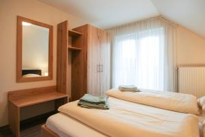 een slaapkamer met twee bedden en een spiegel bij Familienhof Brüning - Stadtblick in Meppen +8 foto's