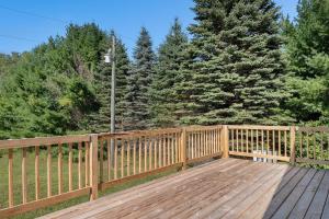 a wooden deck with a fence and trees at Platte River Play Lovely 2bdr Barnhouse 2852 in Beulah