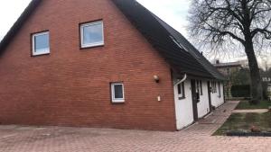 a red brick building with three windows on it at FEWO Ostseeland in Grömitz