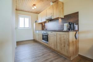 a kitchen with wooden cabinets and a stove at Ferienhof Büdlfarm - Haus in Fehmarn