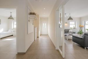 a hallway leading to a living room with white walls at Ferienhaus Seeblick in Walchum
