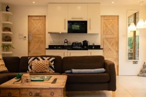 Sala de estar con sofá marrón y mesa de centro en The Hideaway - A cosy retreat by the lakes, en South Cerney