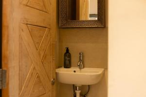 Un baño con lavabo y puerta de madera. en The Hideaway - A cosy retreat by the lakes, en South Cerney 9 fotos más