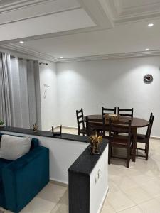 a dining room with a table and a blue couch at Résidence el fassi in Fès