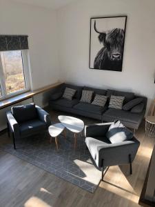 a living room with a couch and a bull picture at Landhaus am See 934 in Biersdorf