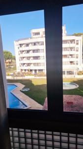 a window with a view of a building and a pool at Apartment in Vilamoura with pool in Quarteira