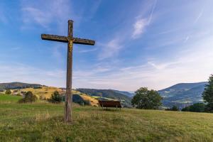 a wooden cross in a field with a bench at Gästehaus Holzer Kreuz- Gästezimmer Margerite für 2 Personen inkl Landfrühstück in Fröhnd +2 photos