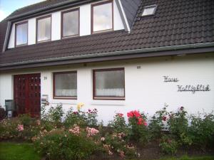 Ein weißes Haus, das seitlich geschrieben ist. in der Unterkunft Haus Halligblick, Ferienwohnungen am Wattenmeer, Whg Oland in Dagebüll