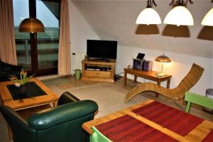 ein Wohnzimmer mit Sofa und Fernseher in der Unterkunft Haus Halligblick, Ferienwohnungen am Wattenmeer, Whg Oland in Dagebüll + 5 Fotos