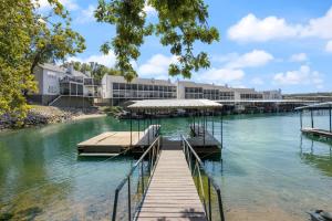 レイク・オザークにあるLuxury waterfront lakehouse with private dock viewsの建物を背景にした川沿いの埠頭