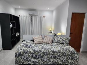a bedroom with a bed and a couch with pillows at Aire y Sol in Concordia