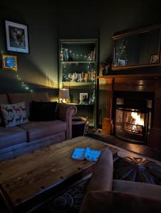 德里门Mulberry Lodge Guest Suite - luxurious accommodation on West Highland Way的带沙发和壁炉的客厅