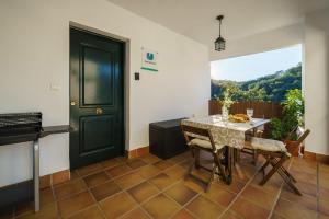 a dining room with a table and a window at Casas La Buganvilla Aracena in Aracena