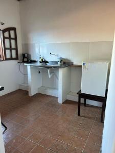 a kitchen with a counter and a white refrigerator at La Mar Paraty Hospedaria 03 in Paraty