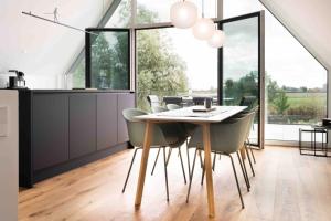 NeufunnixsielHarlepadd 3c的配有桌椅的厨房和餐厅