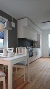 Una cocina blanca con una mesa y sillas blancas. en Ökohaus Spaden, en Spaden 12 fotos más