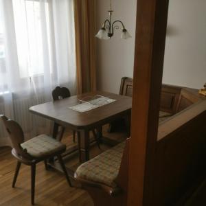 een eetkamer met een tafel en twee stoelen en een tafel en een raam bij FeWo-POR24 Pfronten in Pfronten