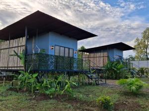 a blue house with a fence in front of it at Arenal Tiny Lodge #1 in San Francisco