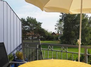 a yellow table with an umbrella on a fence at FeWo 40 "Haus Kormoran - W3" in Prerow