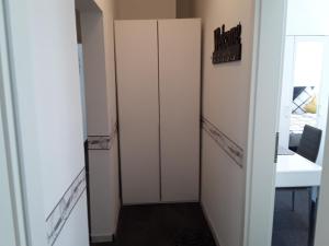 a hallway with two white closets and a table at Ferienwohnung Weiland 80qm in Lutherstadt Eisleben
