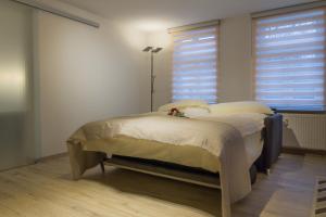 a small bed in a room with two windows at Ferienwohnung am Schlosspark in Bad Harzburg