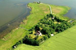 un'isola nell'acqua con una casa sopra di Ferienwohnung 7 mit Wasserblick, Balkon 2 Pers a Neuenkirchen Altre 5 foto