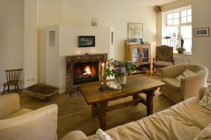 un soggiorno con camino e tavolo di Ferienwohnung 7 mit Wasserblick, Balkon 2 Pers a Neuenkirchen