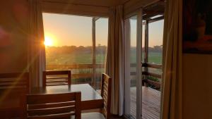 a room with a table and a balcony with the sunset at Casa de Miramar in Miramar