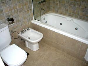 a bathroom with a toilet and a tub and a sink at Casa de Miramar in Miramar