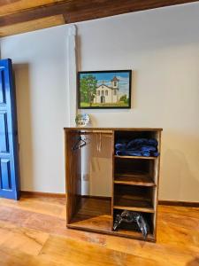 a shelf in a room with a painting on the wall at Vesperata Diamantina in Diamantina