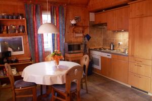 a kitchen with a table with a vase of flowers on it at Ferienhaus Seeadler in Userin