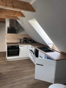 a kitchen with white cabinets and a ceiling at Ferienwohnung am Storchnest in Kenz