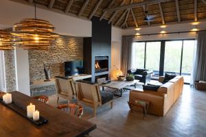 ein Wohnzimmer mit Couch und Kamin in der Unterkunft Villa Visvanger - Villa with river deck nearby Kruger in Hoedspruit