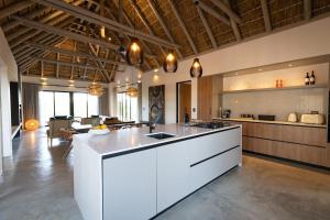 eine große Küche mit einer weißen Insel in einem Raum in der Unterkunft Villa Visvanger - Villa with river deck nearby Kruger in Hoedspruit