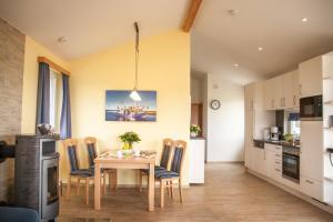 a kitchen and dining room with a table and chairs at Ferienhaus Strandnixe in Dorum Neufeld +14 photos