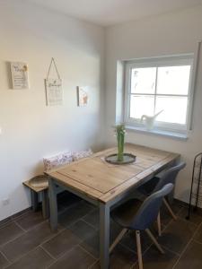 une table à manger avec des chaises et une fenêtre dans l'établissement Im Blauen Ländchen, à Lierschied 10 autres photos