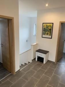 une pièce avec une cage d'escalier avec un banc et une cage d'escalier dans l'établissement Im Blauen Ländchen, à Lierschied