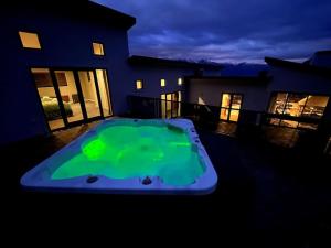 una gran piscina verde frente a una casa en Luxury On Wynyard 4 Bedrooms Stunning Views, en Queenstown