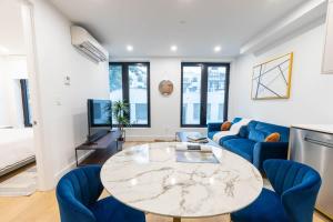 a living room with a table and blue chairs at 202 New Condo 1BR in Prime Greenpoint in Brooklyn