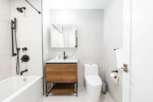 a white bathroom with a sink and a toilet at 202 New Condo 1BR in Prime Greenpoint in Brooklyn