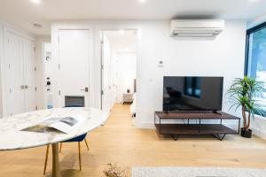 a living room with a table and a tv at 202 New Condo 1BR in Prime Greenpoint in Brooklyn +45 photos